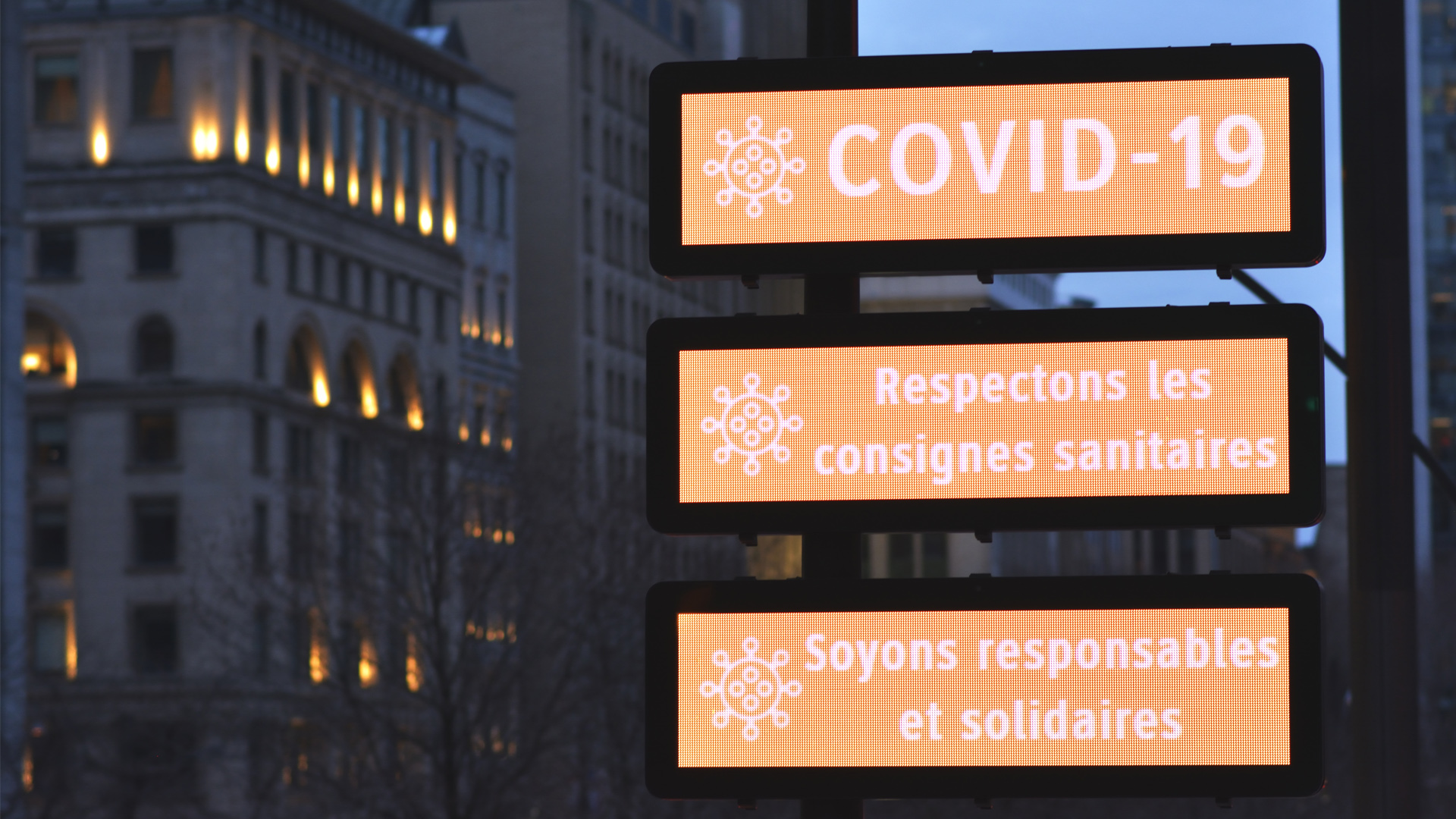 Illuminated signs in Montreal urging caution about COVID-19.