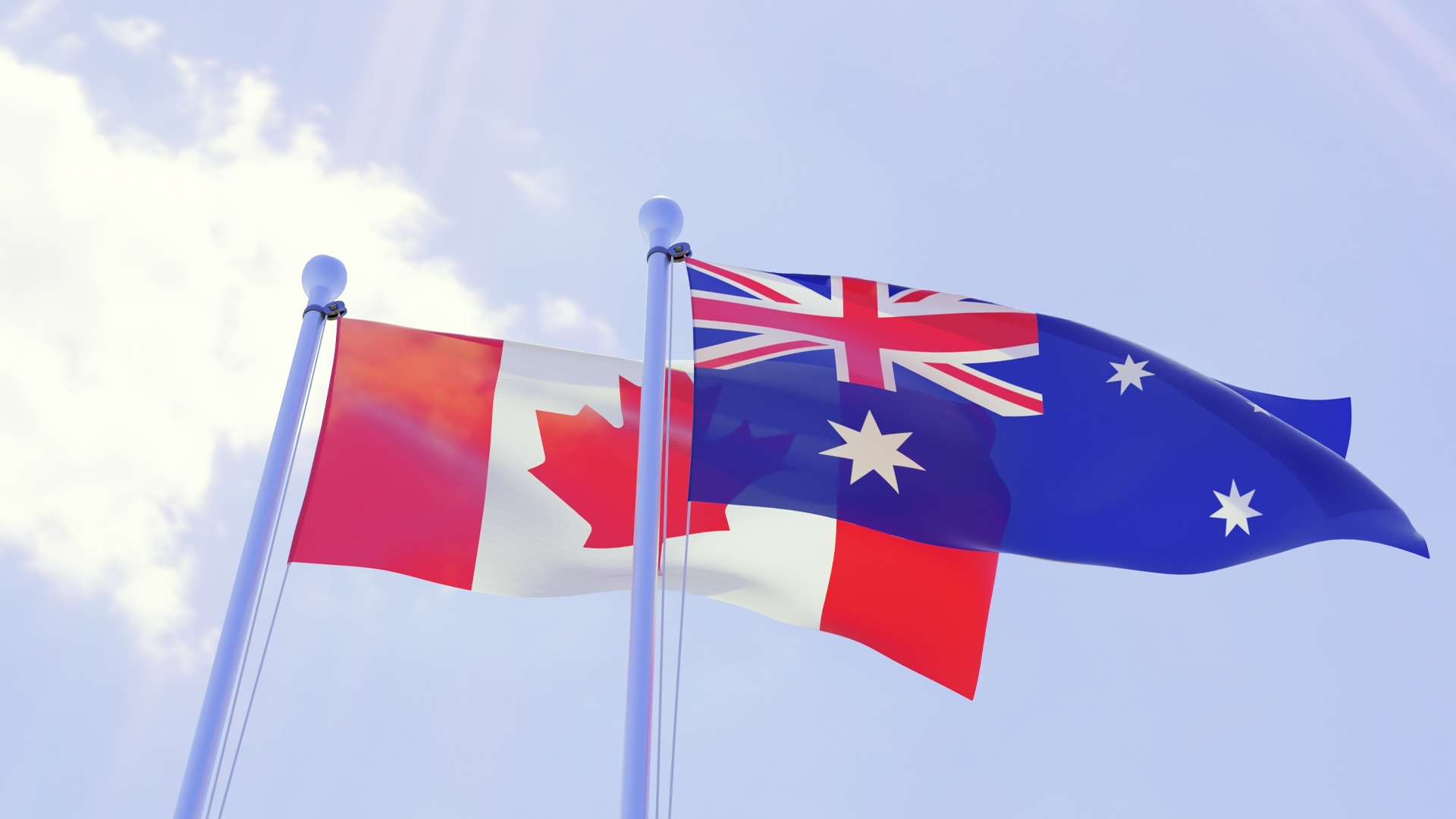 Canadian and Australian flags flutter against a blue sky.