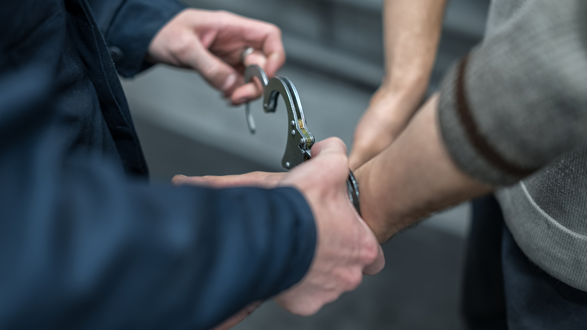 Handcuffs are placed on the wrists of a man.