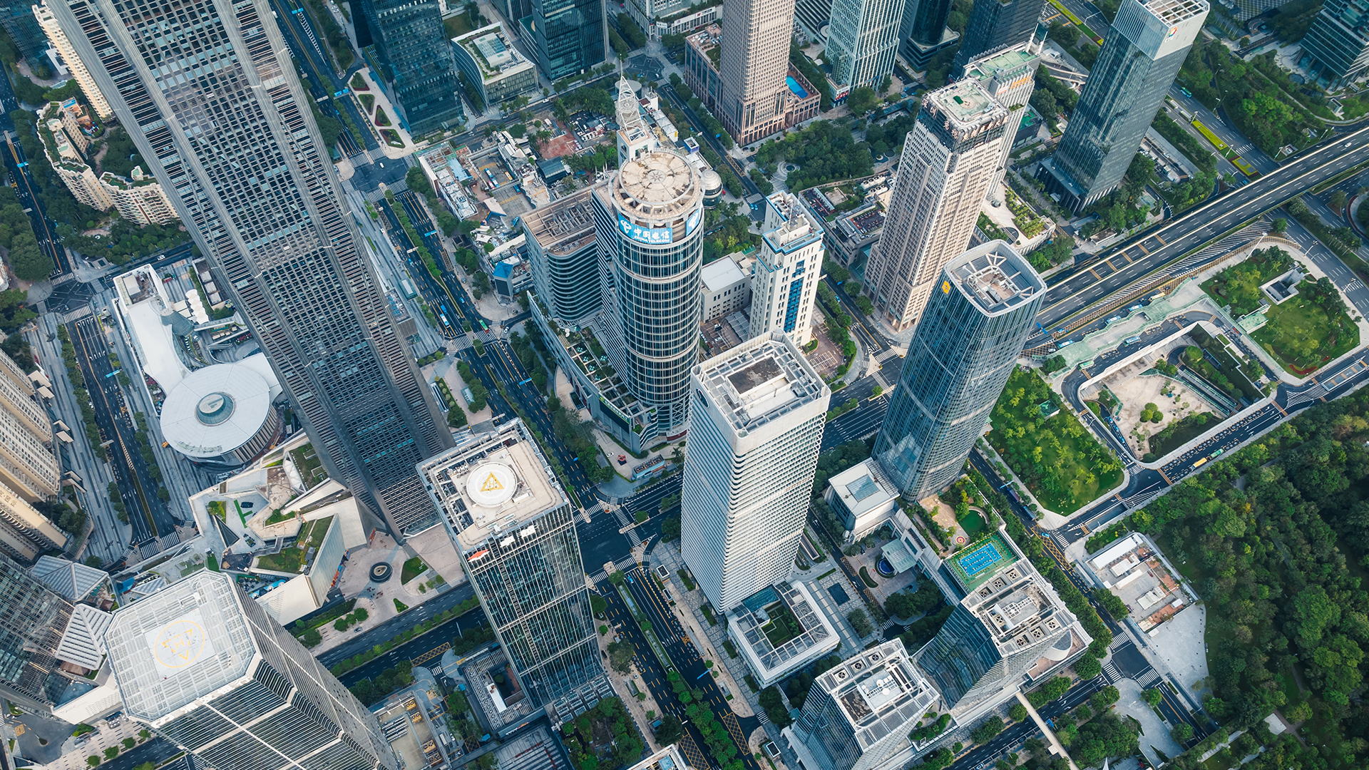 Aerial view of the city showing a district with skyscrapers, multi-lane streets and green spaces.