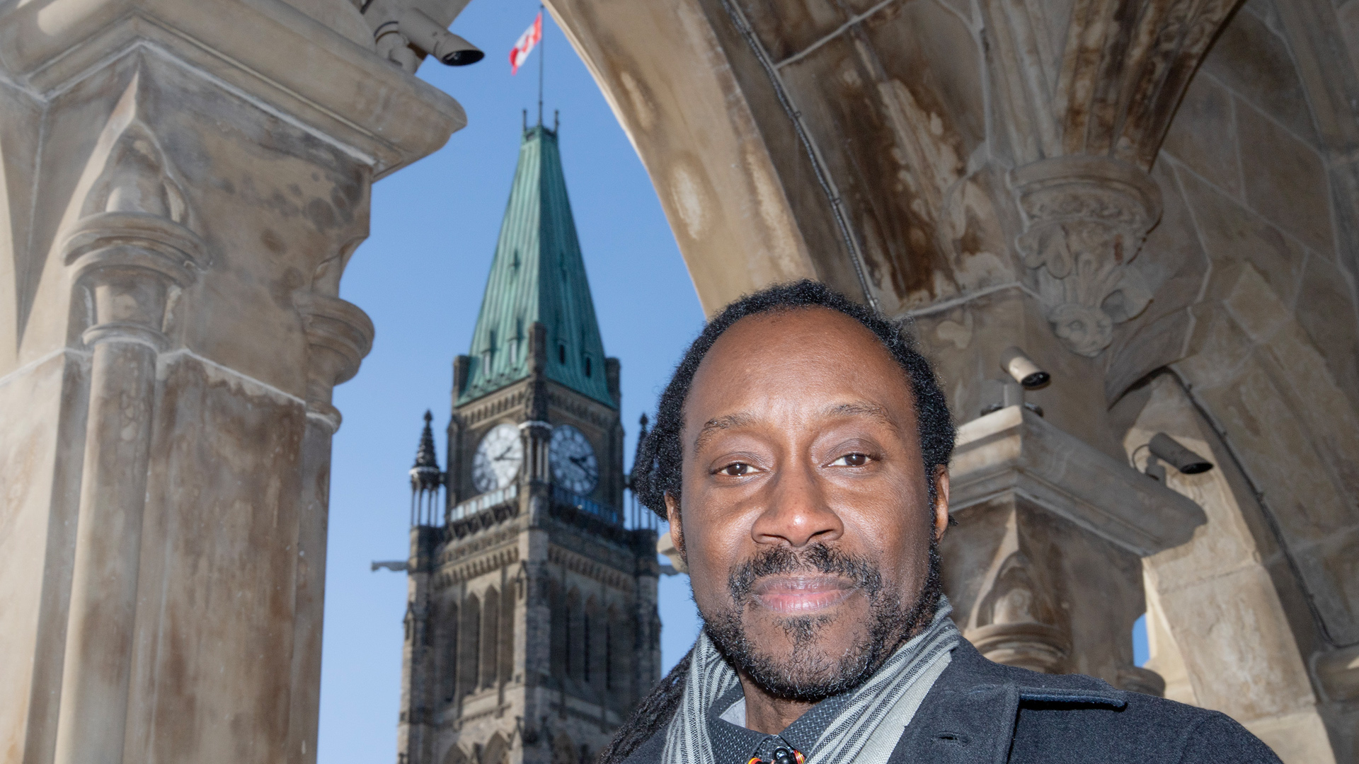 Richard Sharpe is pictured across the street from Parliament. The Peace Tower can be seen with a Canadian flag flying at the top.