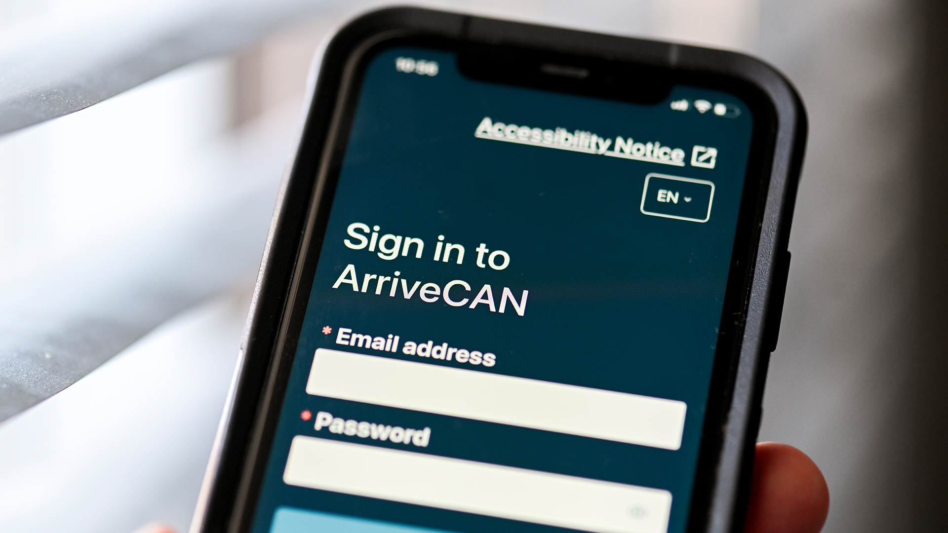 La page d’ouverture de session de l’application ArriveCAN est affichée sur l’écran d’un téléphone intelligent tenu par une personne.