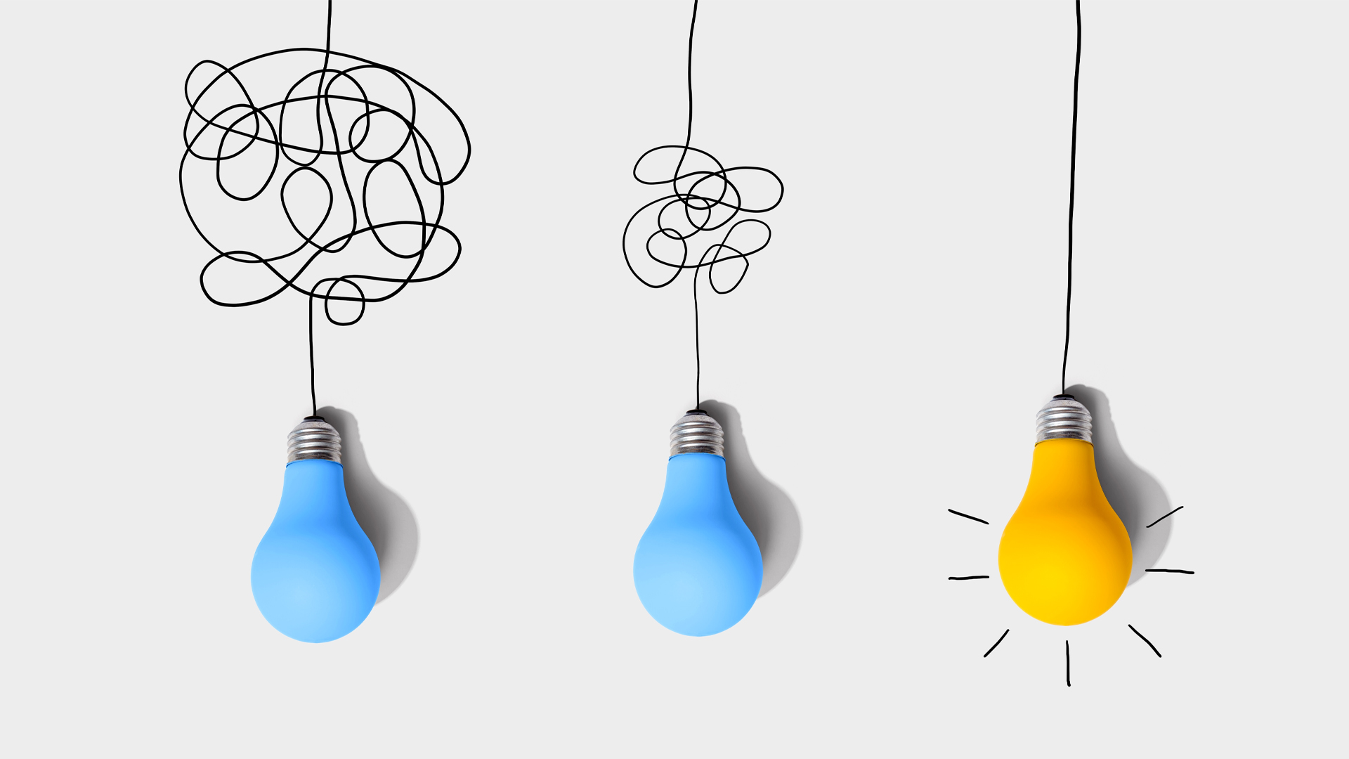 Three lightbulbs hang from drawn black lines. The first line is tangled up hopelessly. The second one is minimally tangled. The third is untangled.