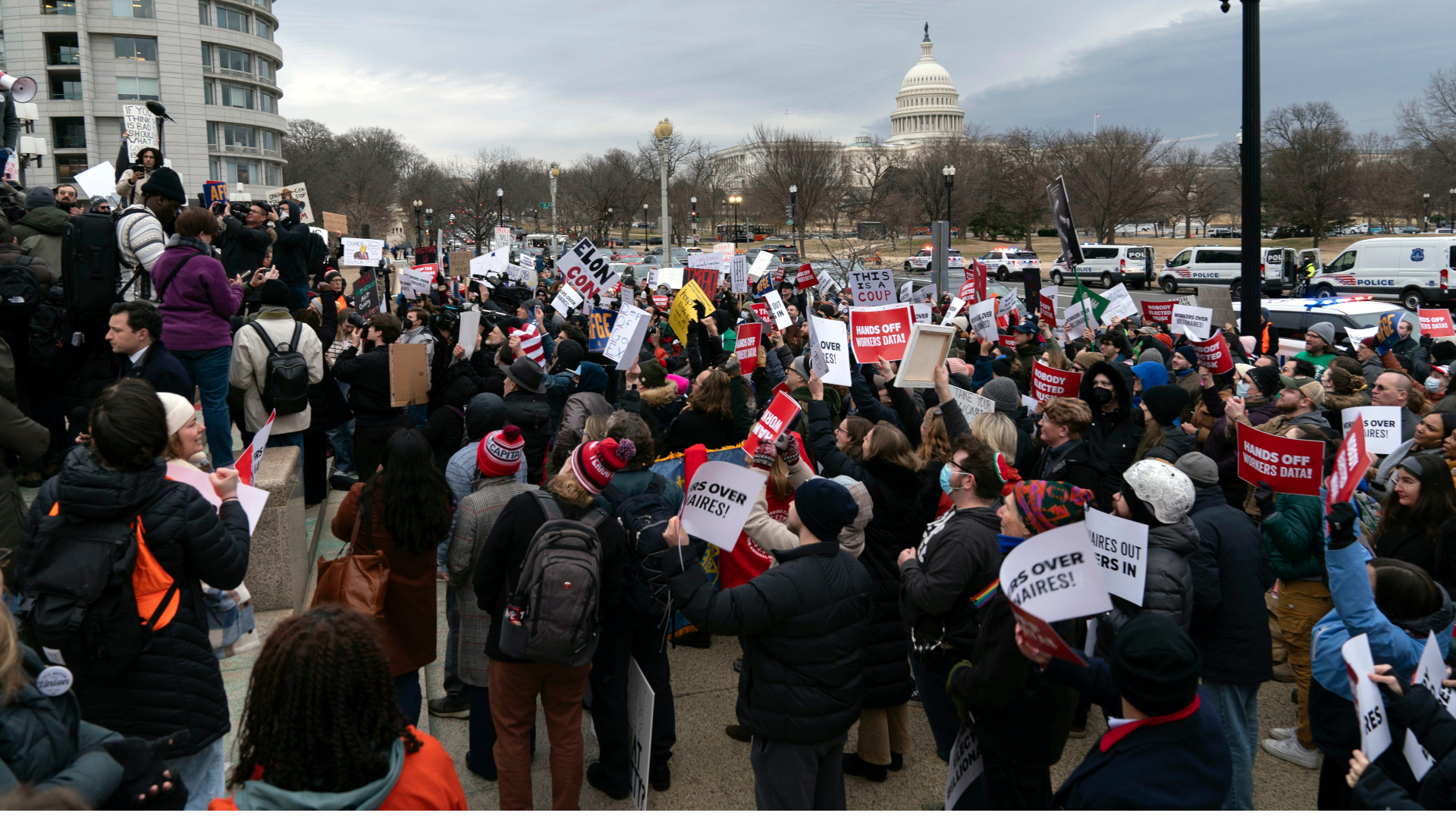 Une foule de personnes brandissent des pancartes devant un édifice du gouvernement aux États-Unis. En arrière-plan, on aperçoit l’édifice du Capitole.
