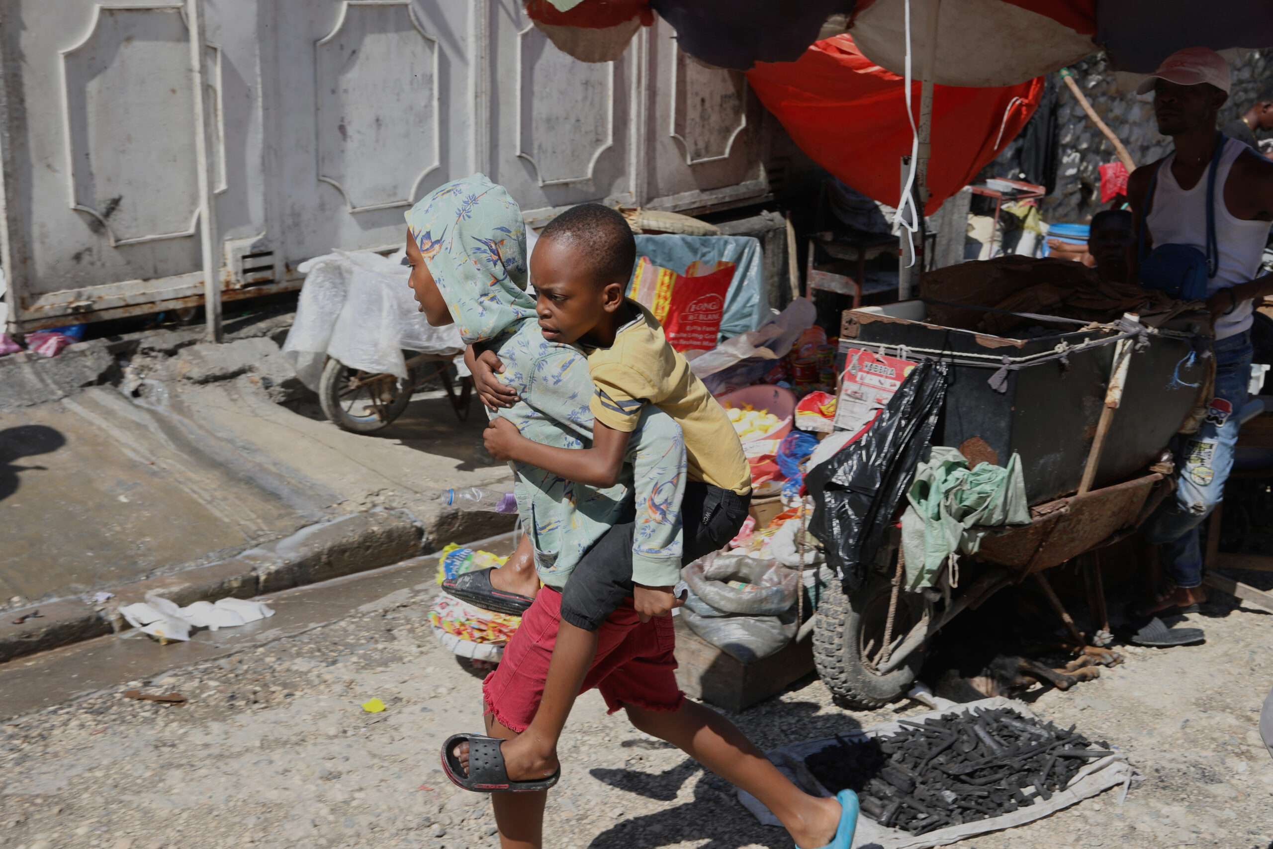 Deux enfants traversent un marché de Port-au-Prince, en Haïti.