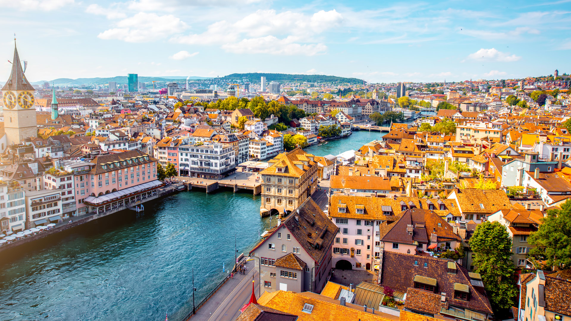 A river runs through the city, lined with tightly packed homes and buildings about four or five storeys high.